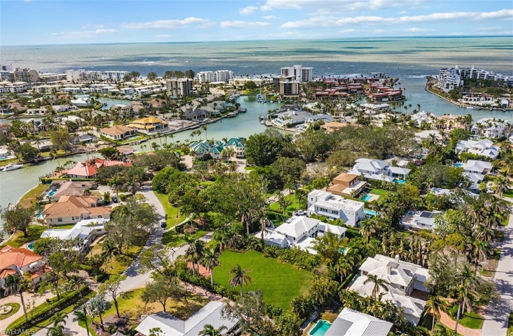 Aerial view of Moorings homes and canals, with waterfront condominiums and the Gulf beyond.