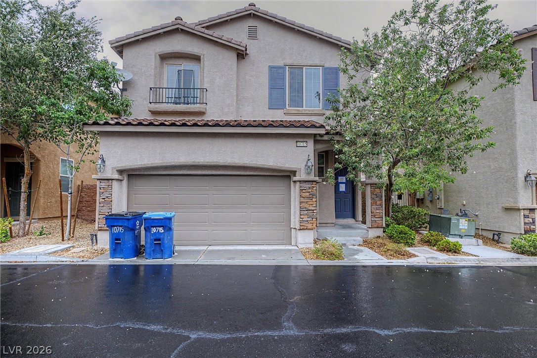 Two-story stucco home with a double garage, blue front door, and stone accents.