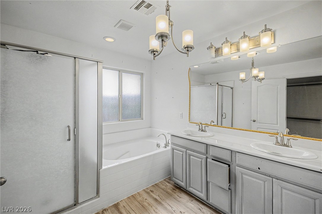 Bathroom with a glass shower, bathtub beneath a frosted window, and long double-sink vanity.