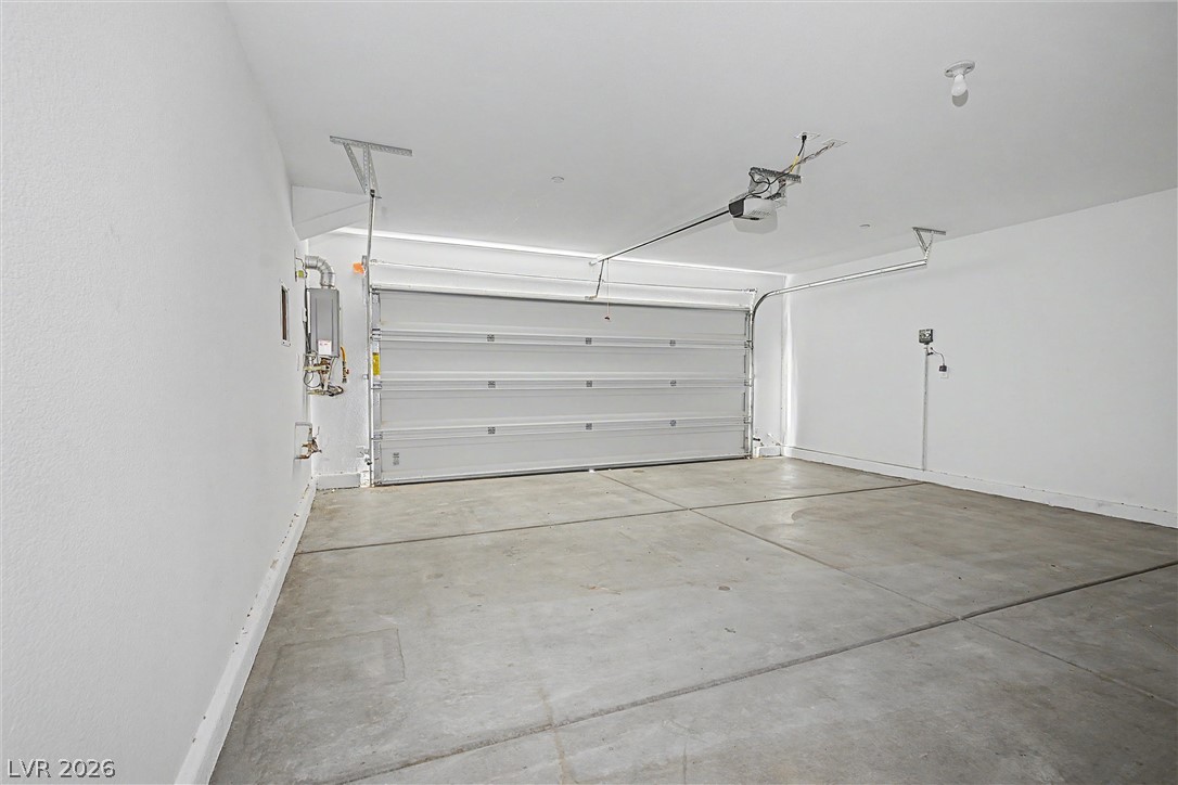 Empty garage with a concrete floor and closed sectional garage door.