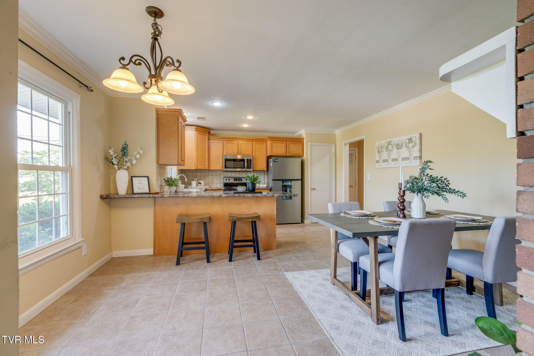 Open kitchen and dining area with a wood-cabinet breakfast bar and a set dining table.