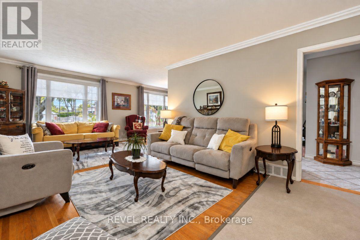 Living room with gray and yellow sofas, a marble-patterned rug, and large windows.