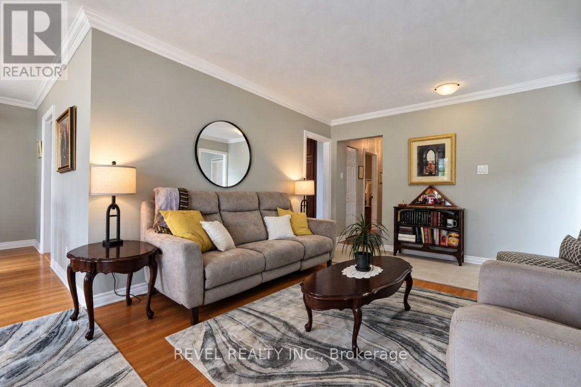 Living room with a gray sectional, yellow pillows, round mirror, and patterned rug.