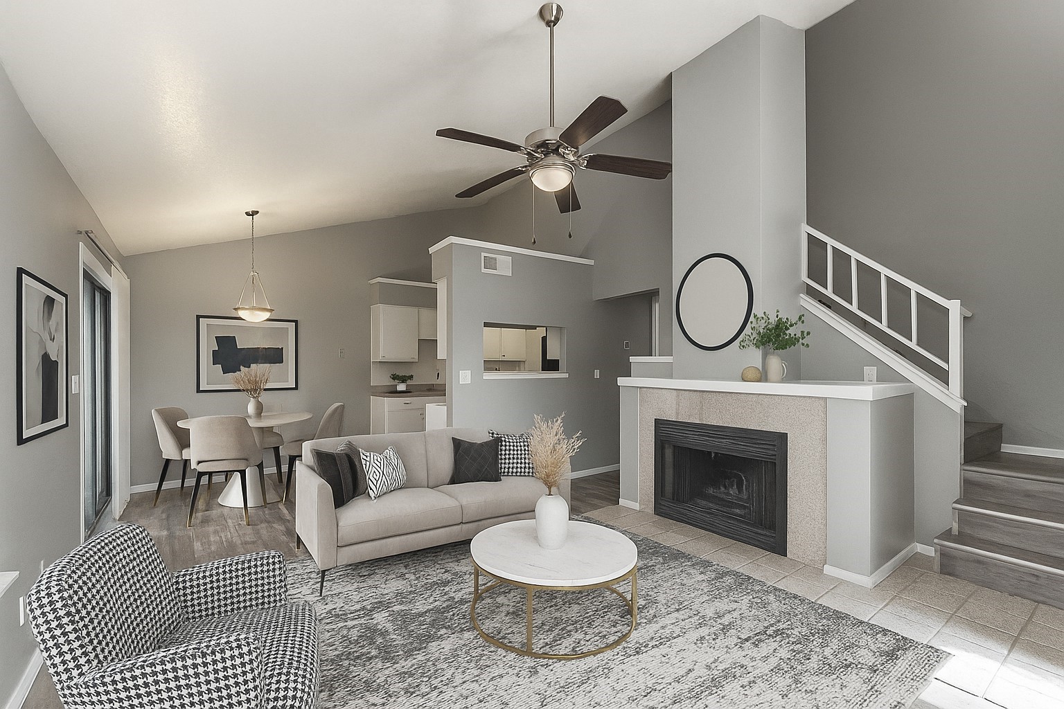 Open-plan living room with a fireplace, vaulted ceiling, and staircase.