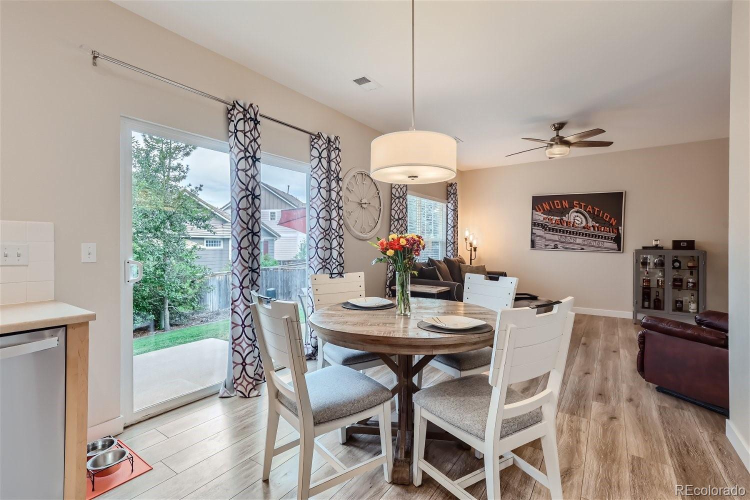 Dining area with a round table, white chairs, and sliding glass door to the patio.