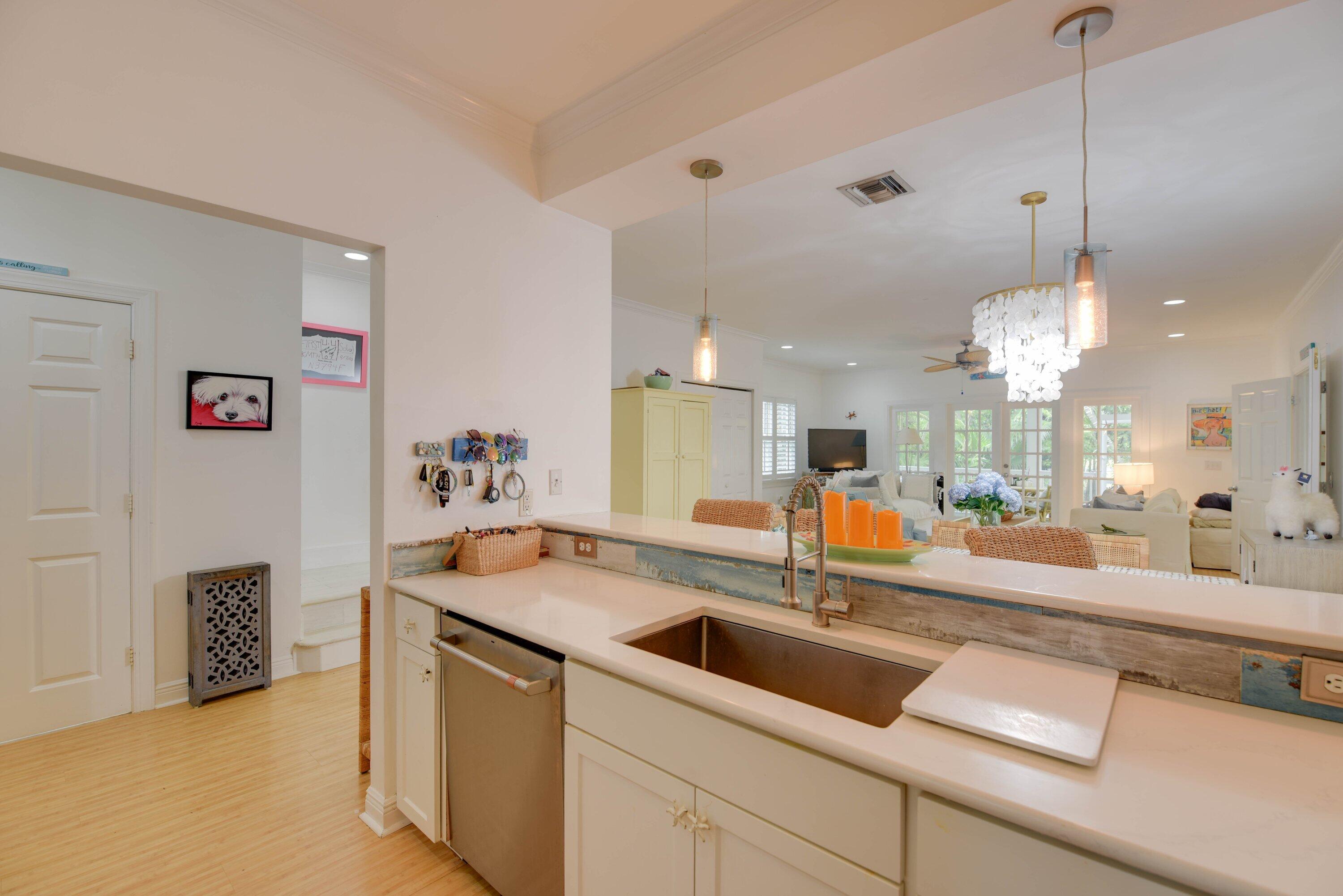Open-plan kitchen with a large island and farmhouse sink overlooking a bright living room.