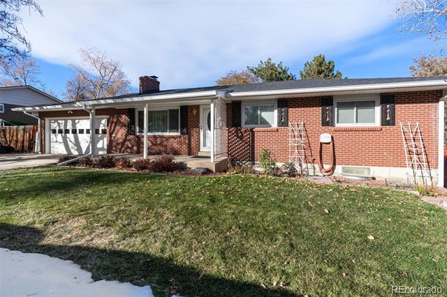 Red-brick single-story home with an attached garage, covered entry, and front lawn.