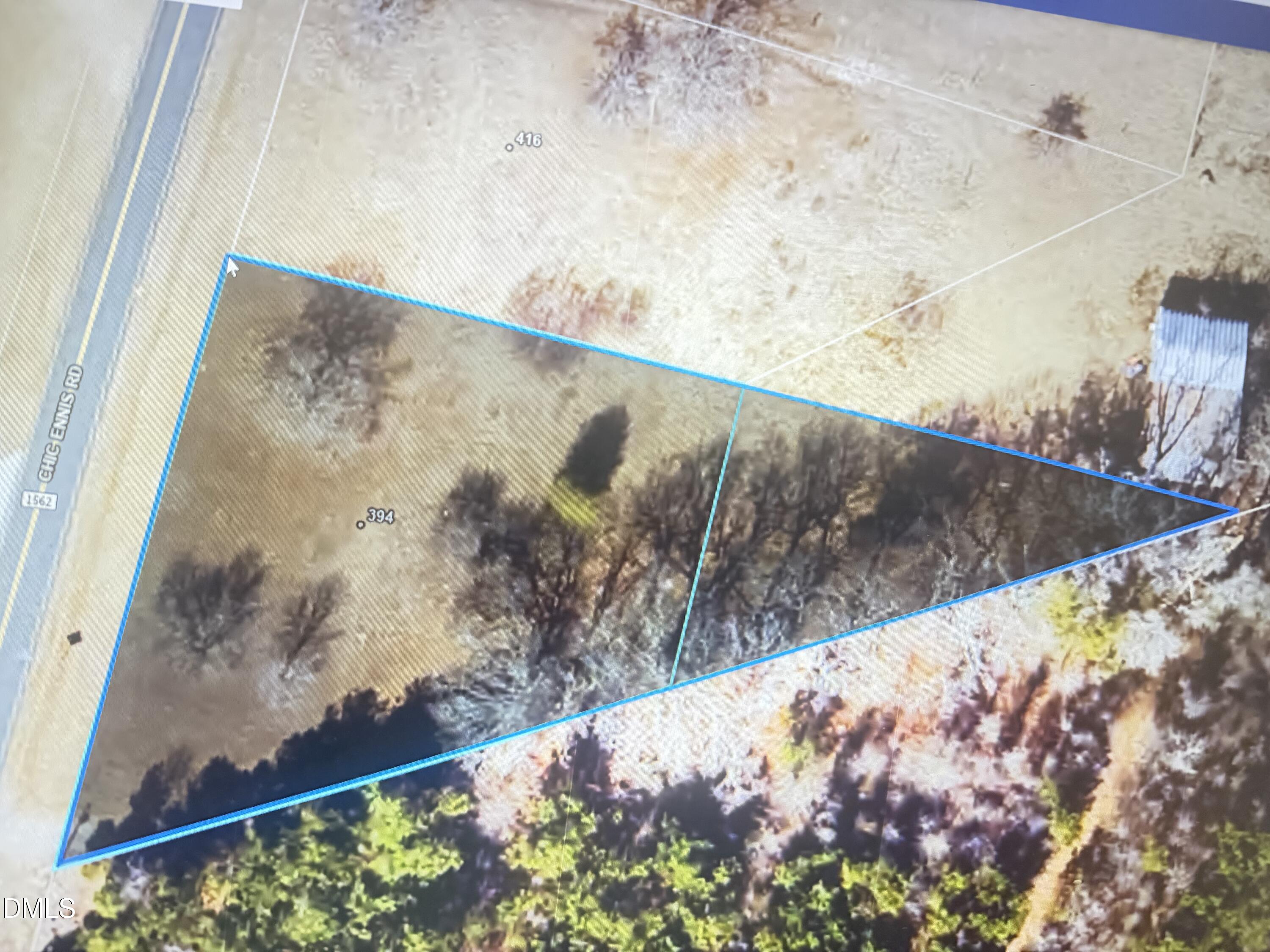 Aerial parcel marked 394, outlined in blue beside Chic Ennis Road, with open ground and trees.