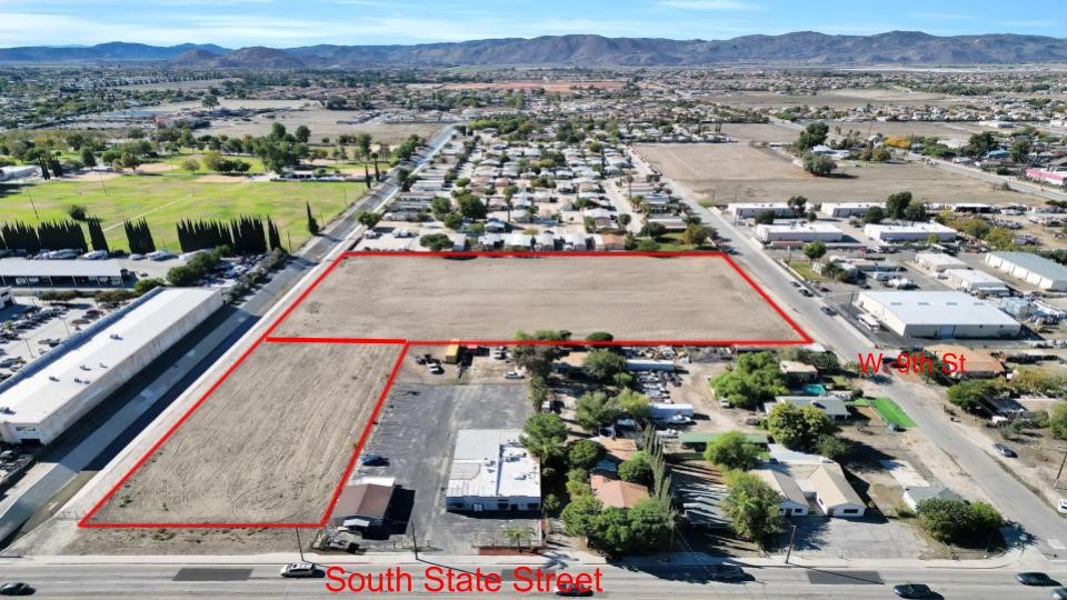 Aerial view of a vacant parcel outlined in red beside South State Street and W 9th St.