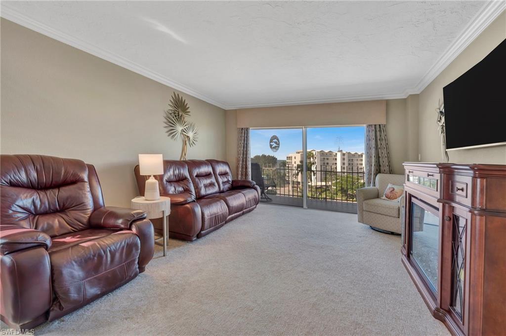 Living room with brown leather seating and sliding doors opening to a balcony.