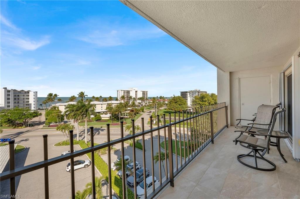 Condominium balcony overlooking the Gulf, with a black railing and two chairs.