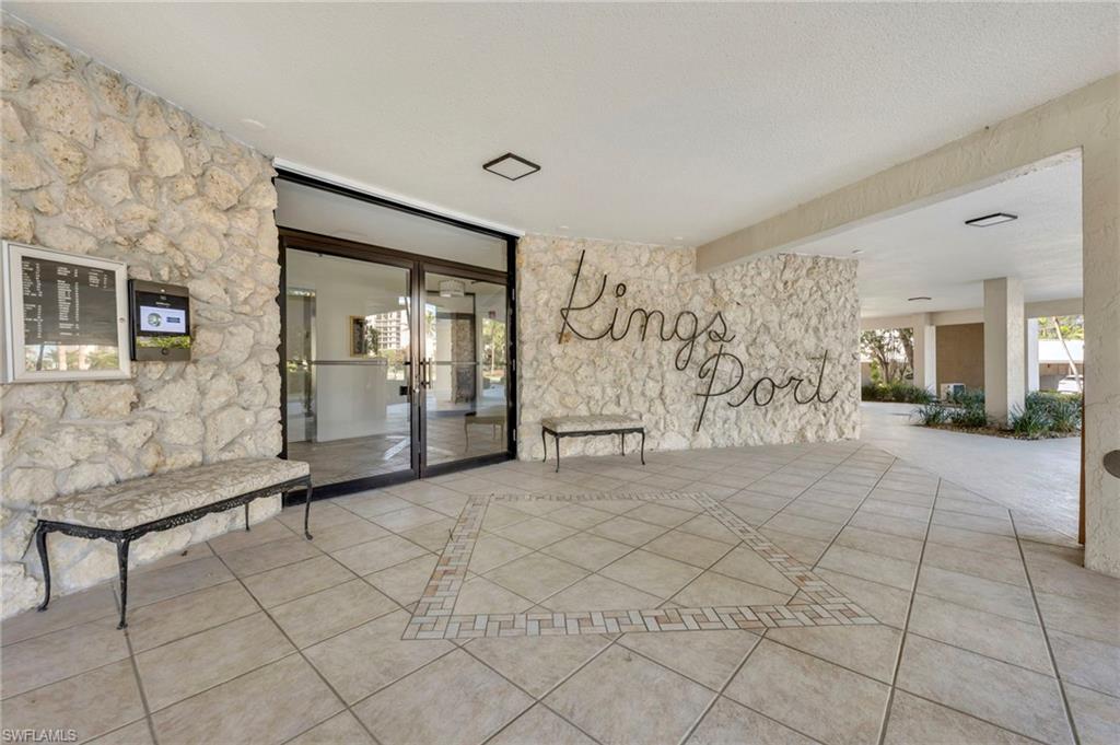 King's Port entrance with stone walls, glass doors, and a patterned tiled floor.