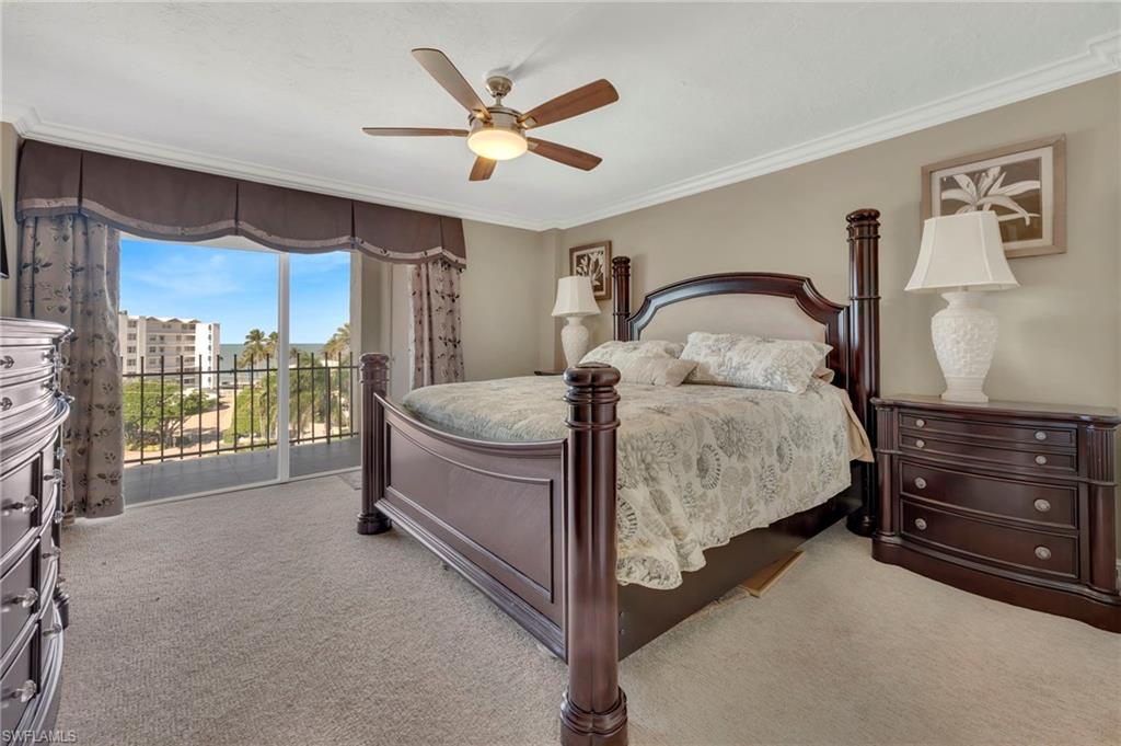 Bedroom with a dark wood four-poster bed and sliding doors opening to a balcony.