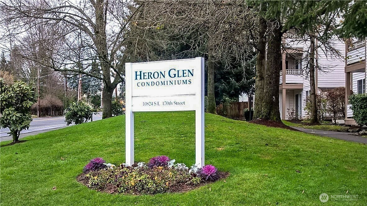 Heron Glen Condominiums sign beside a landscaped lawn and condominium building.
