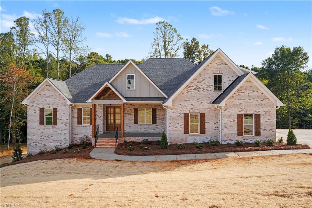 Brick home with multiple gables, brown shutters, and a covered front entrance.