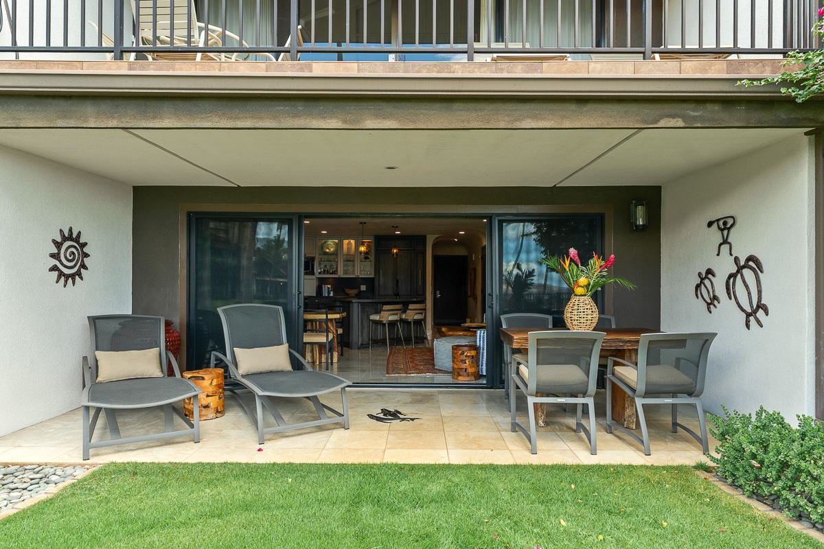 Covered patio with lounge chairs and dining set outside sliding glass doors.