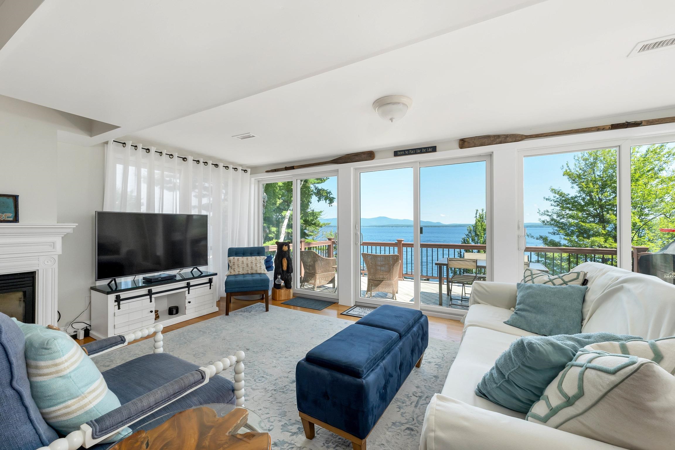 Living room with sliding glass doors overlooking a lake and distant mountains.