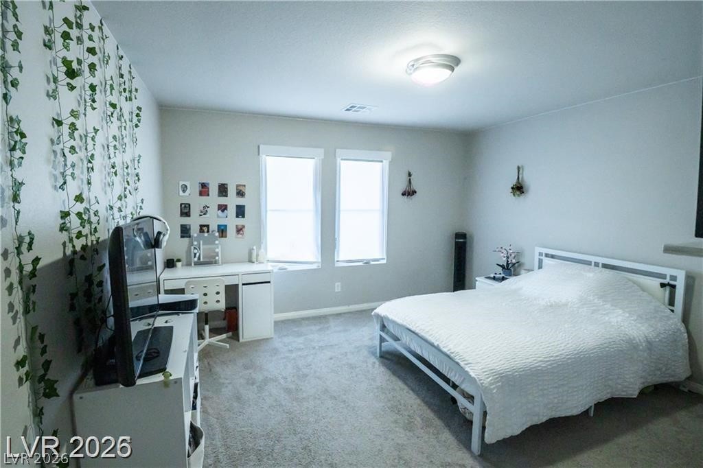 Bedroom with a white bed, gray carpet, and trailing vines along one wall.
