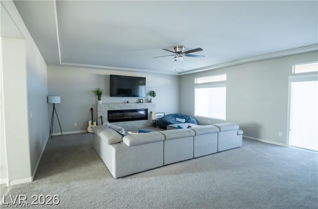 Furnished living room with a large sectional, modern fireplace, and wall-mounted television.