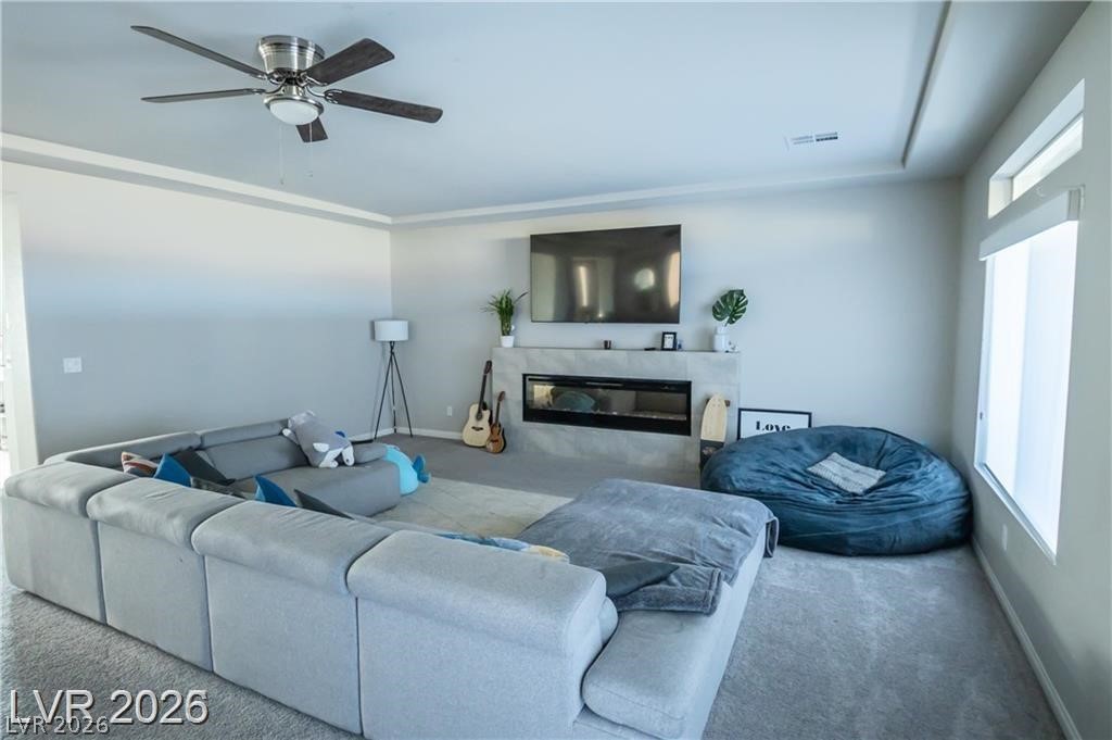 Living room with a gray sectional, blue beanbag chair, and television above a modern fireplace.