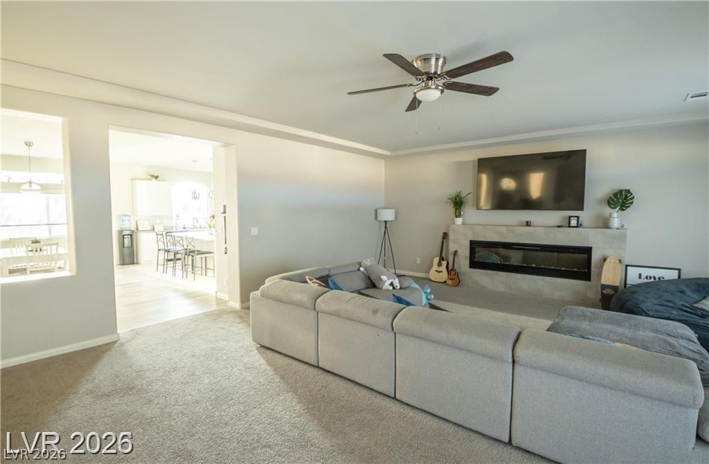 Living room with a large sectional sofa, fireplace, and wall-mounted television.