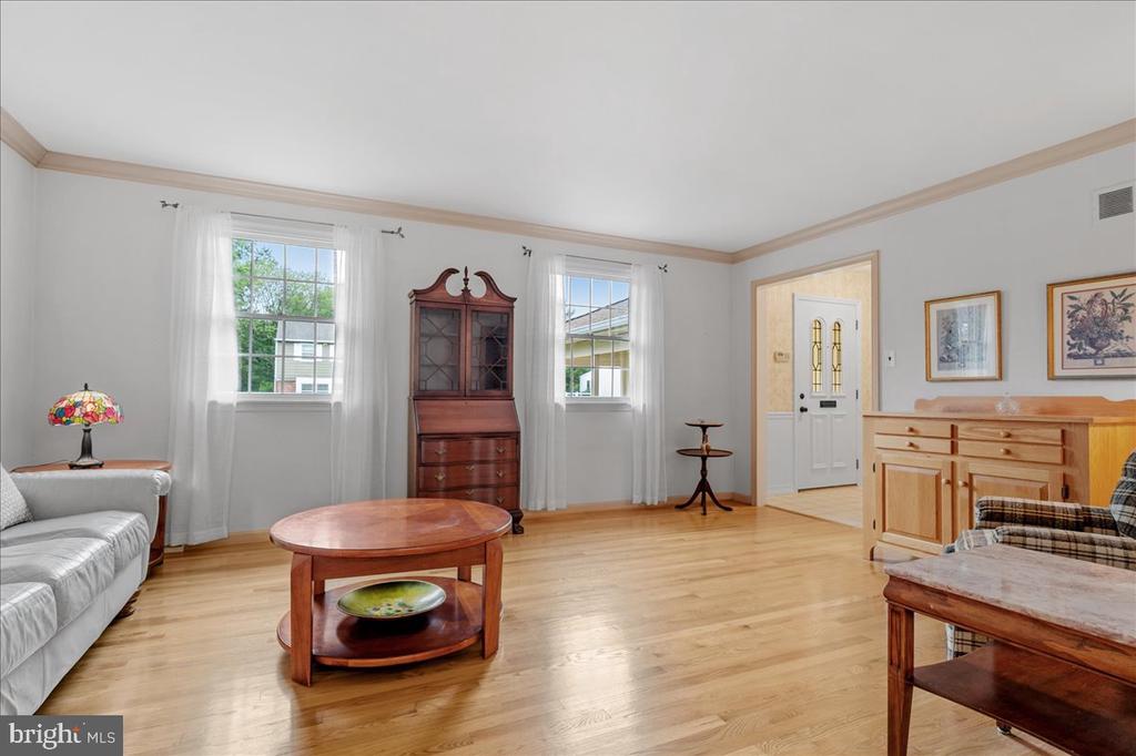 Living room with hardwood floors, a white sofa, and wooden furnishings.