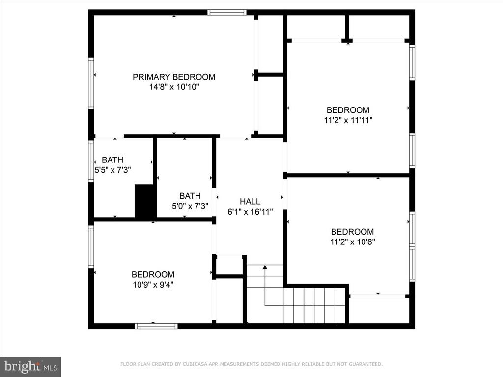 Floor plan showing a primary bedroom, three bedrooms, two bathrooms, hall, and staircase.