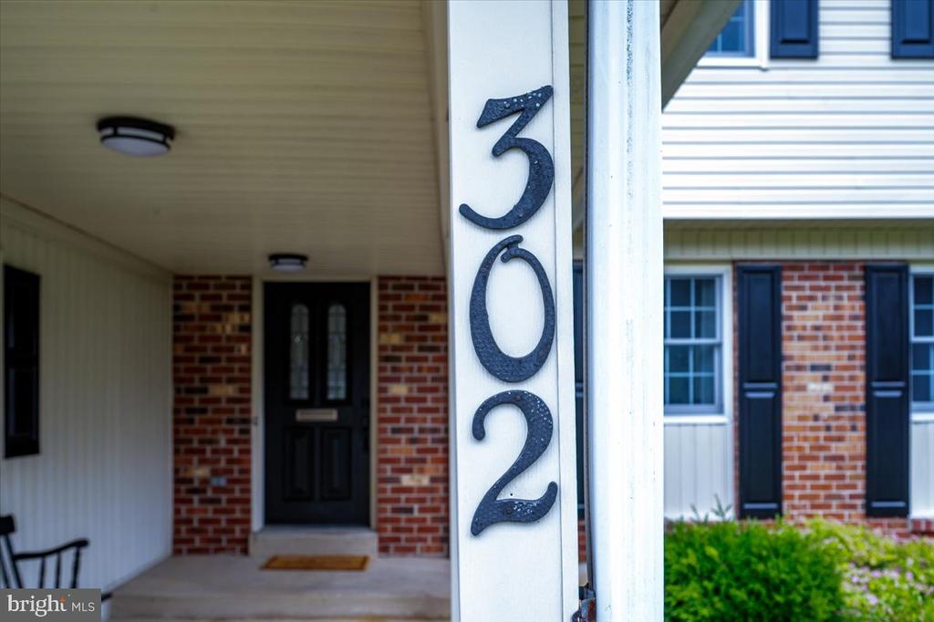 Home entrance at 302 Stamford Drive, with vertical house numbers beside a covered brick porch.