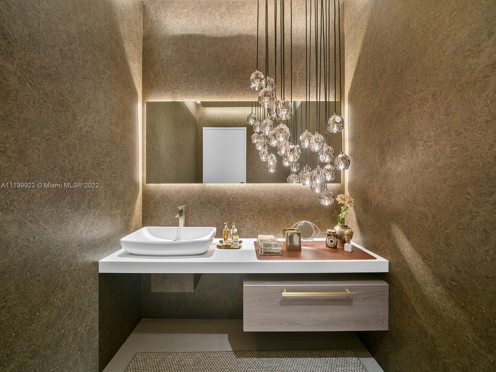 Modern bathroom vanity with a vessel sink, illuminated mirror, and clustered pendant lights.