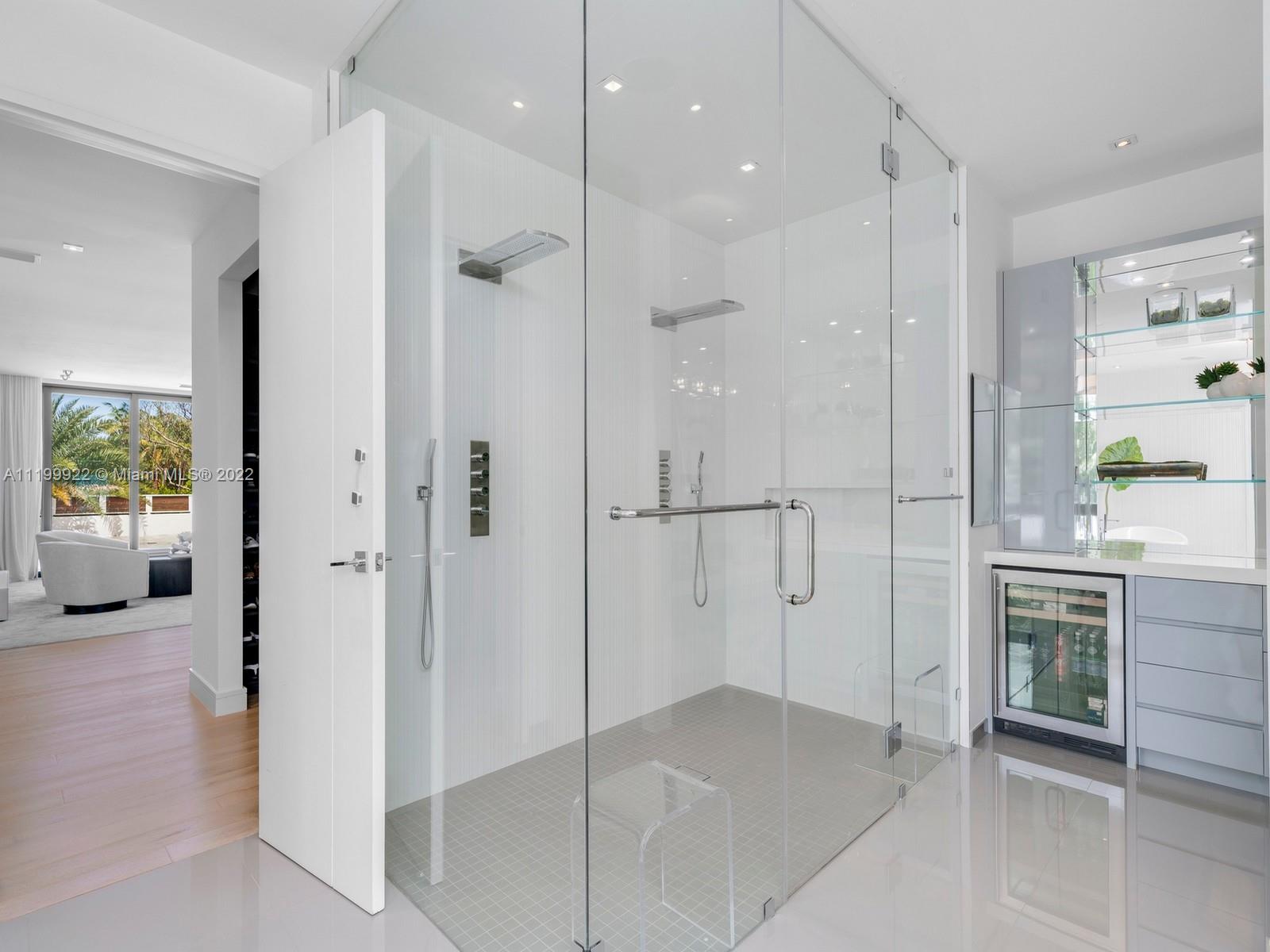 Modern bathroom with a spacious frameless glass shower and built-in wine refrigerator.