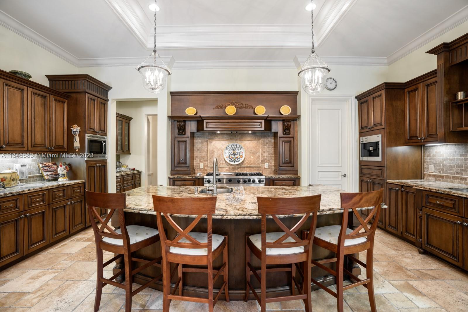 Kitchen with dark wood cabinets, a granite island and seating, and a decorative range hood.