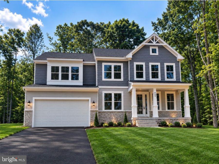 Gray two-story house with a stone façade, attached garage, and covered front porch.