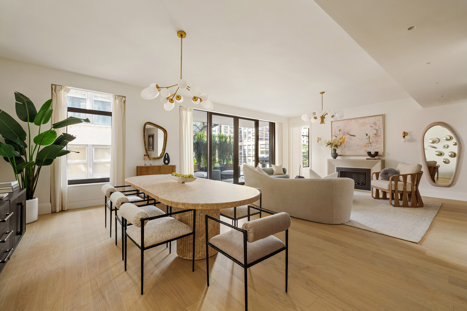Open-plan living and dining room with floor-to-ceiling windows, a fireplace, and contemporary furnishings.