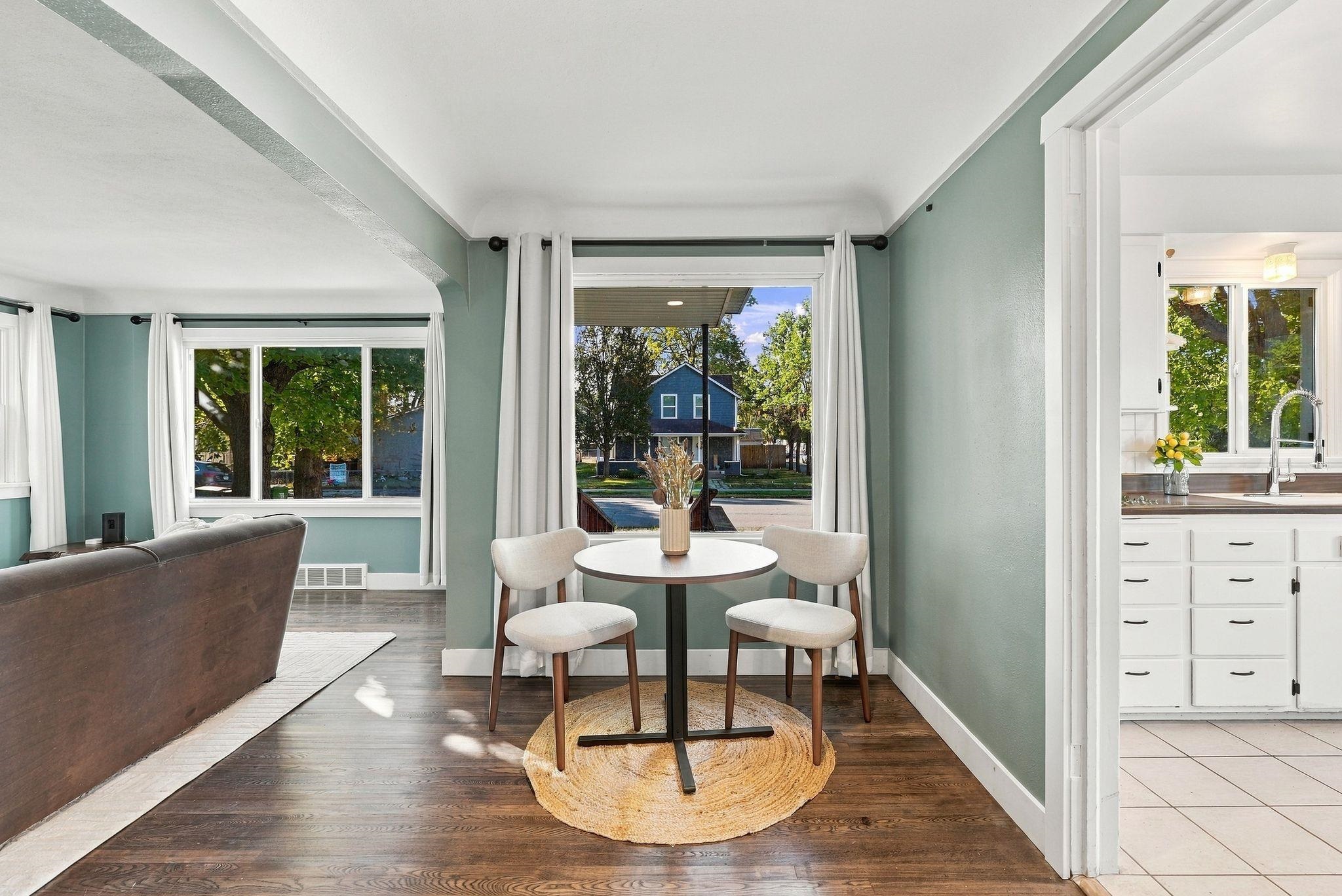 Dining nook with a round table and two chairs beside the living room and kitchen.