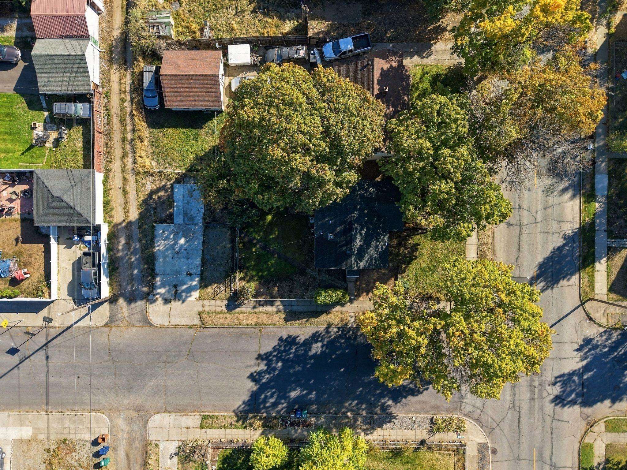 Aerial view of the property, with its house and yard shaded by mature autumn trees.