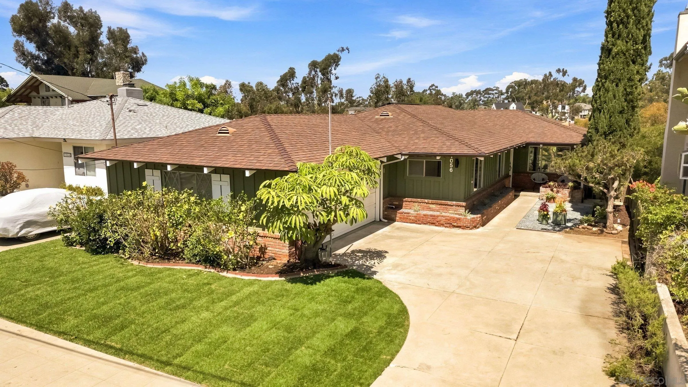 Single-story home with a tiled roof, landscaped lawn, and broad driveway.
