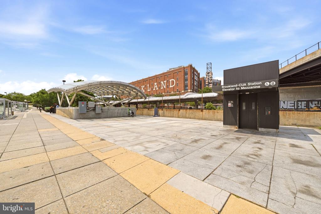 Brookland-CUA Station plaza with a curved canopy and elevator entrance.