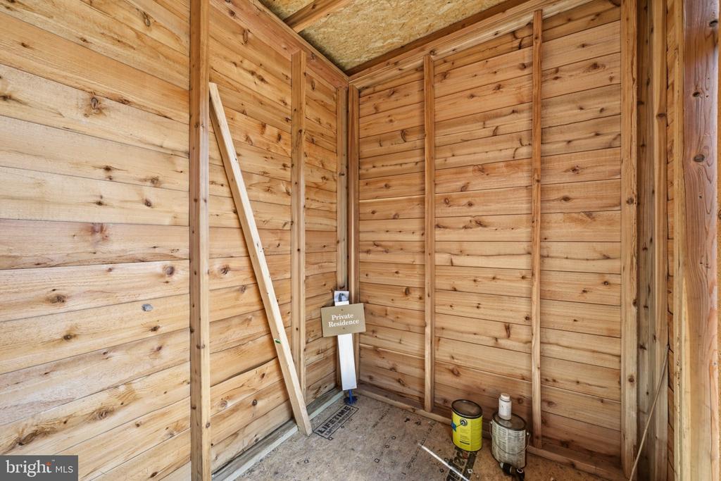 Unfinished wood-paneled interior with exposed framing and a Private Residence sign.