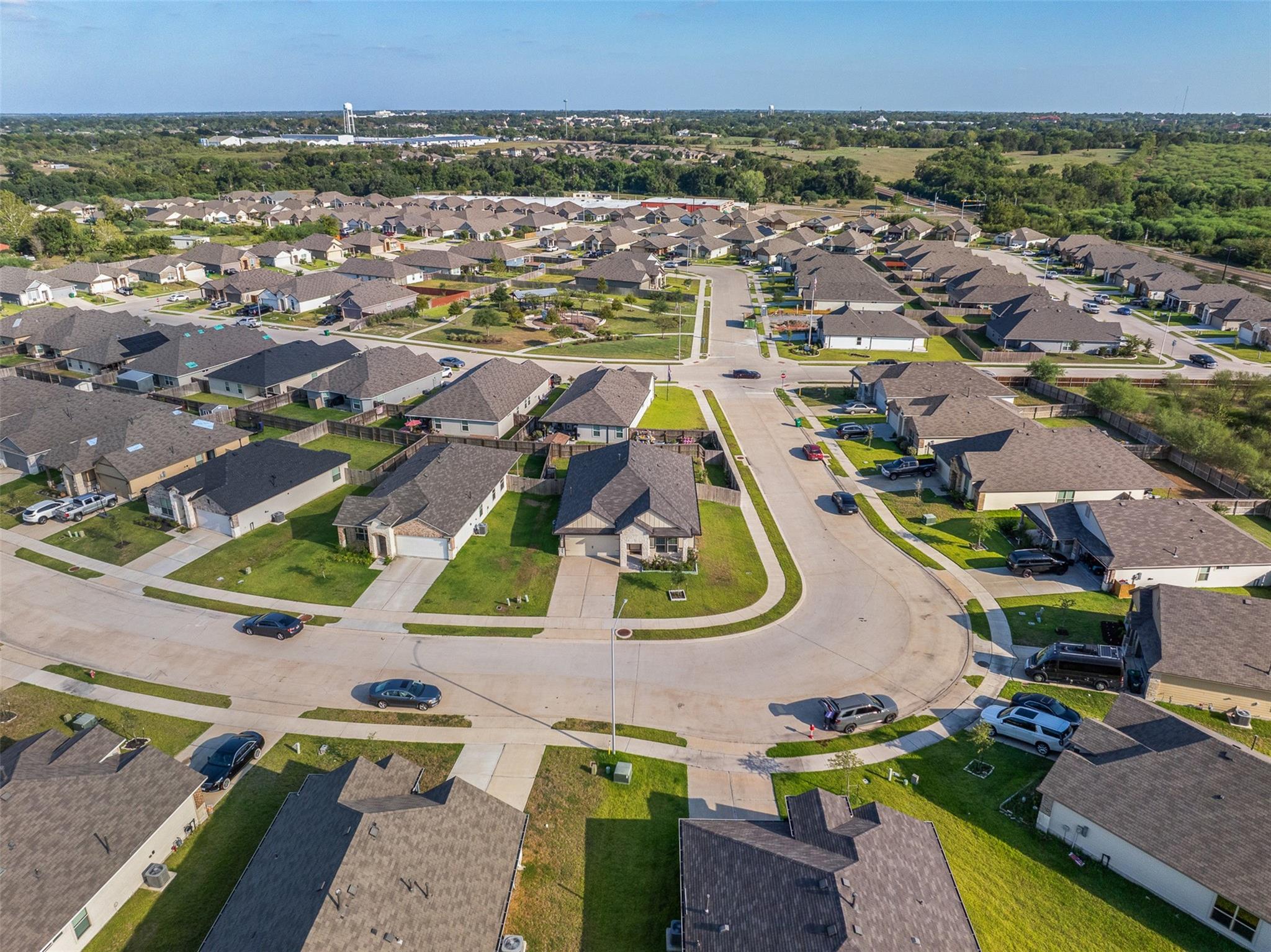 Aerial view of a suburban neighborhood with rows of homes and curving streets.