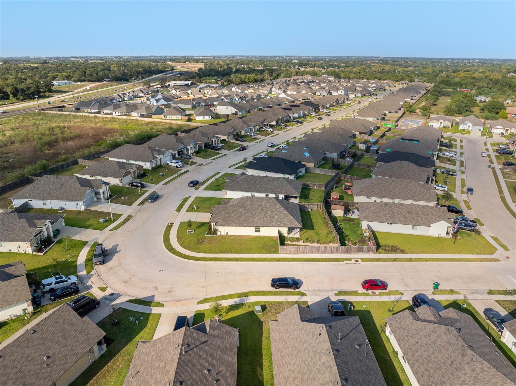 Aerial view of a suburban subdivision with rows of homes and curving streets.