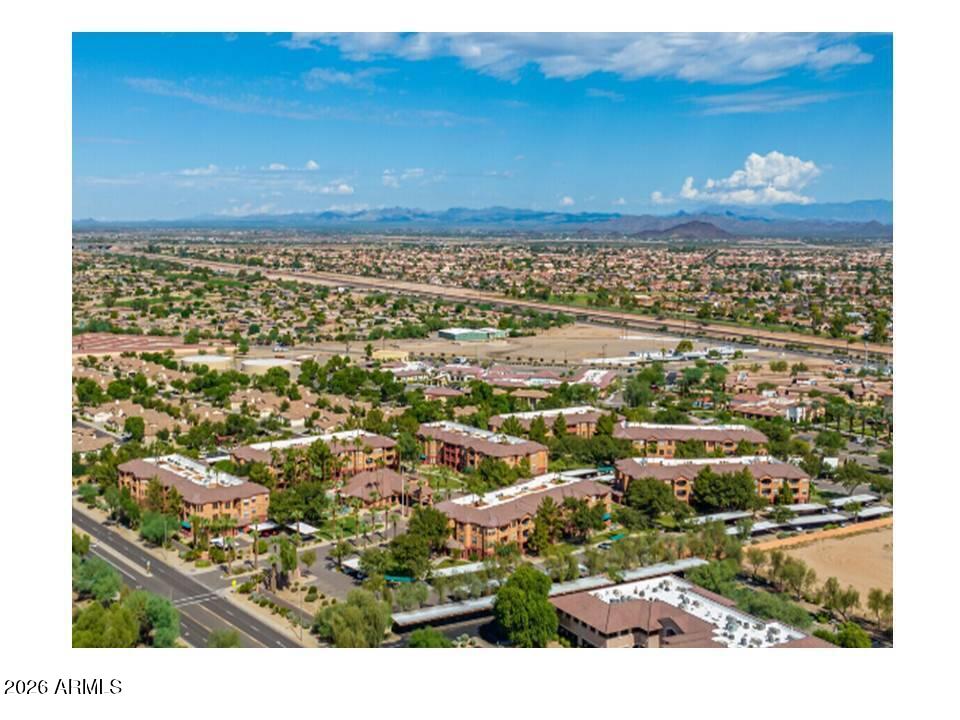 Aerial view of a residential community with suburban neighborhoods and distant mountains.