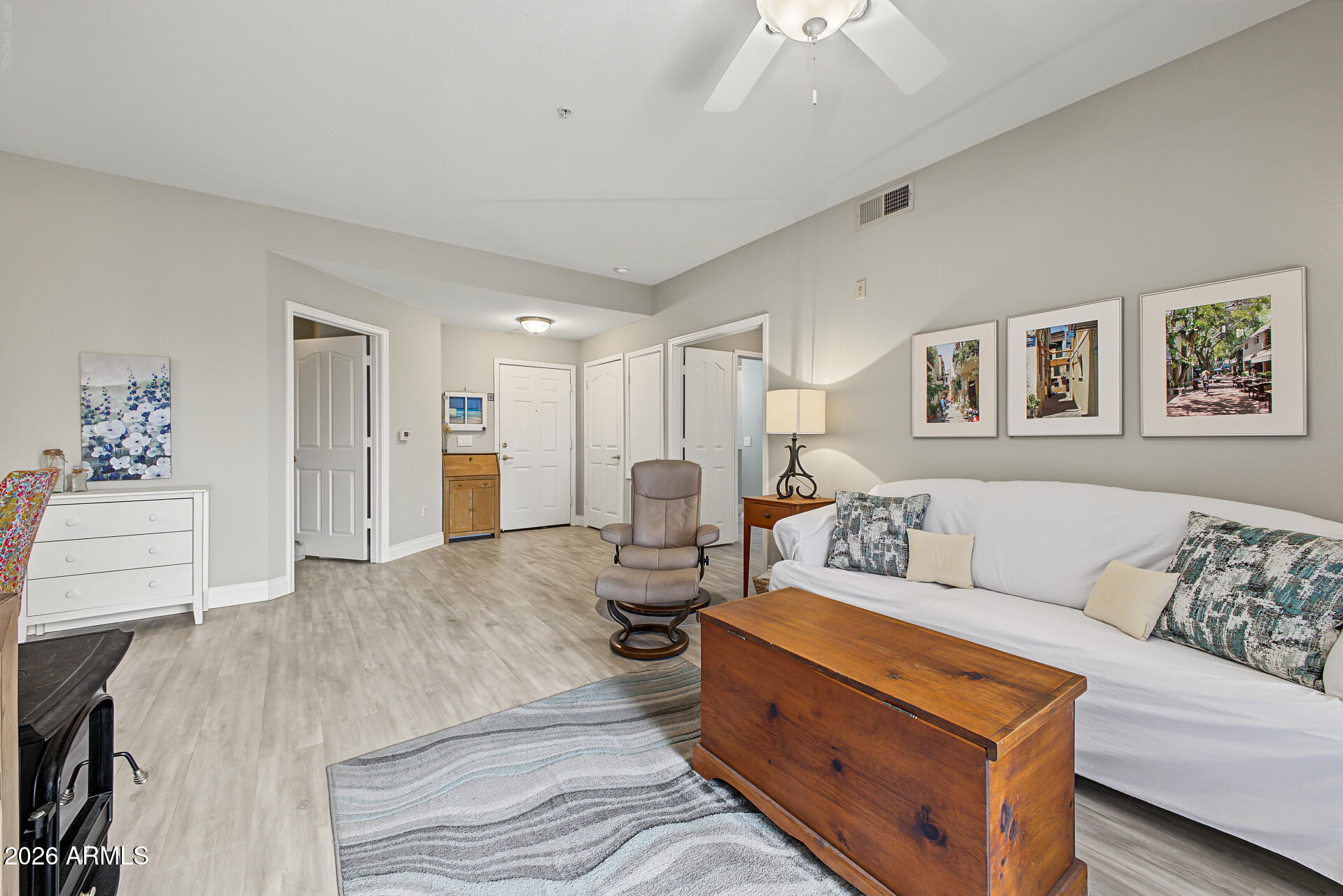 Living room with a white sofa, wood chest coffee table, recliner, and ceiling fan.