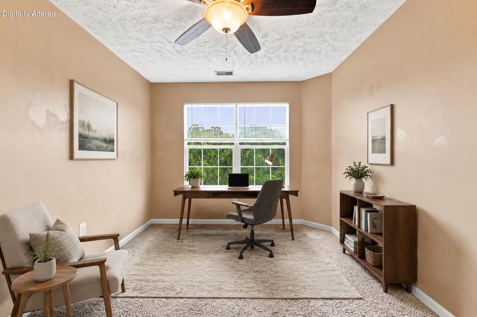 Staged home office with a desk beneath a large window and a bookcase along the wall.