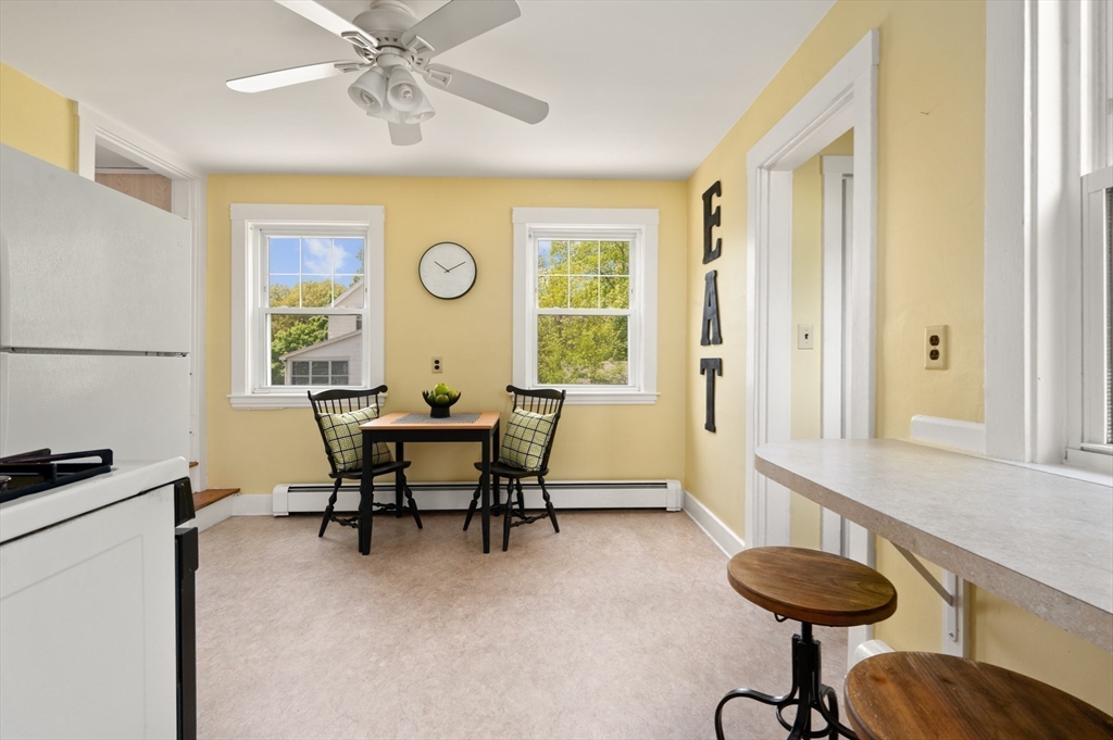 Kitchen with a small dining nook, two windows, and a vertical EAT sign.