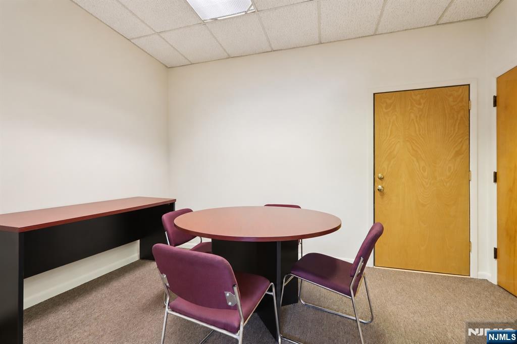 Office meeting room with a round table, purple chairs, and a long wall counter.