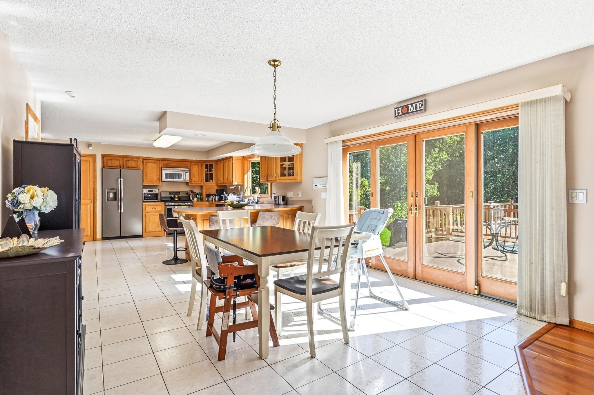 Kitchen and dining area with wood cabinets, a table, and sliding glass doors to a deck.