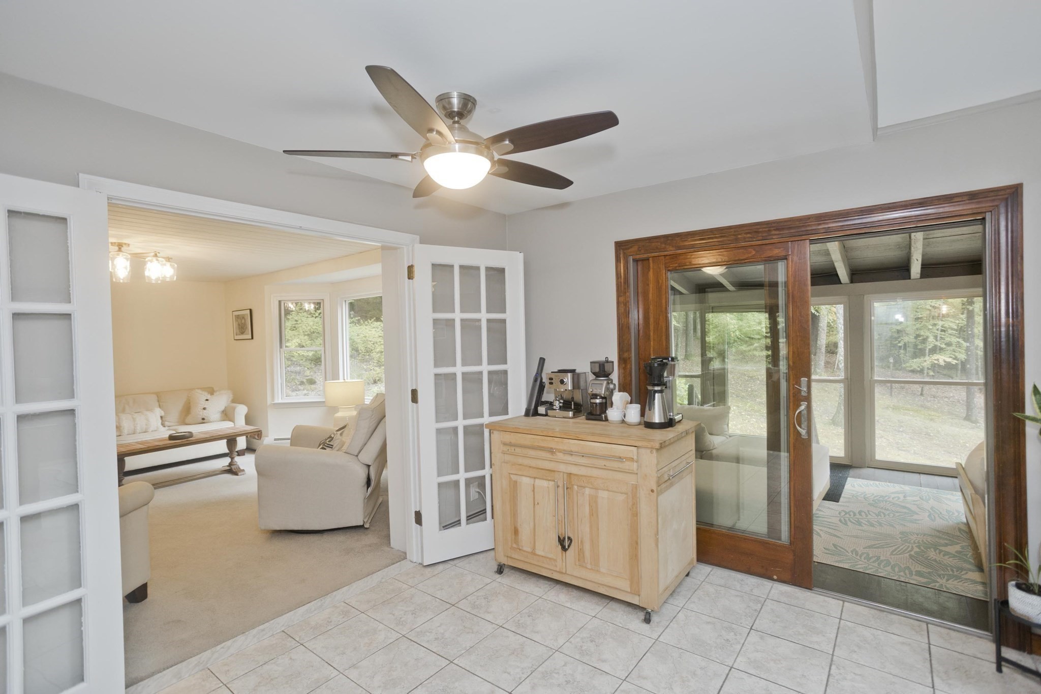 Kitchen with a coffee station, opening to a sitting room and glass-walled sunroom.