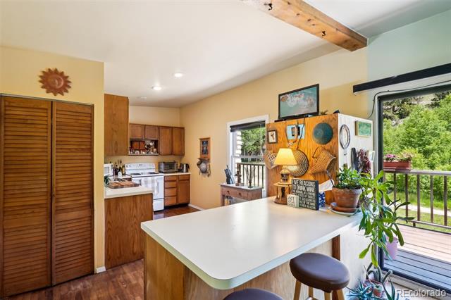 Kitchen with wood cabinets, a large white peninsula, and windows overlooking a wooden deck.