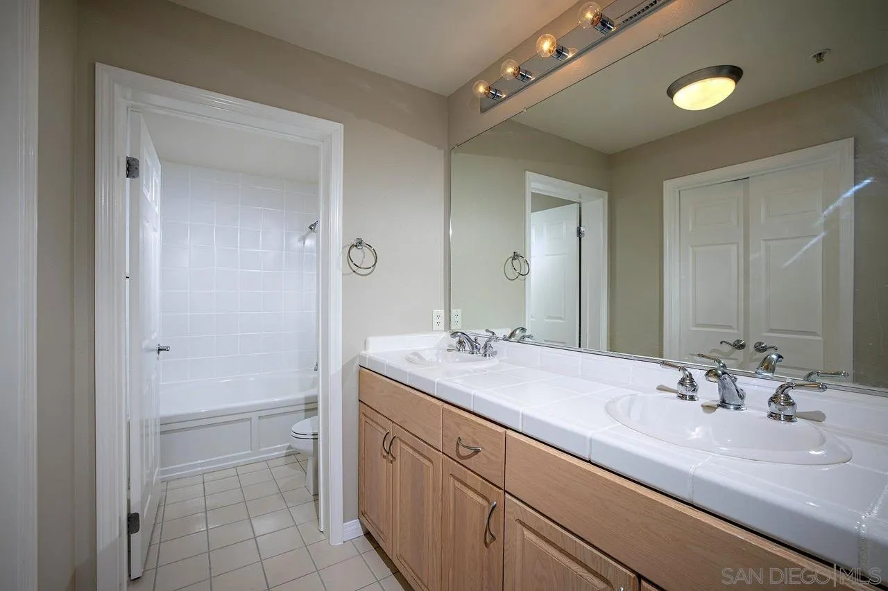 Bathroom with a long double-sink vanity and tiled tub and shower.