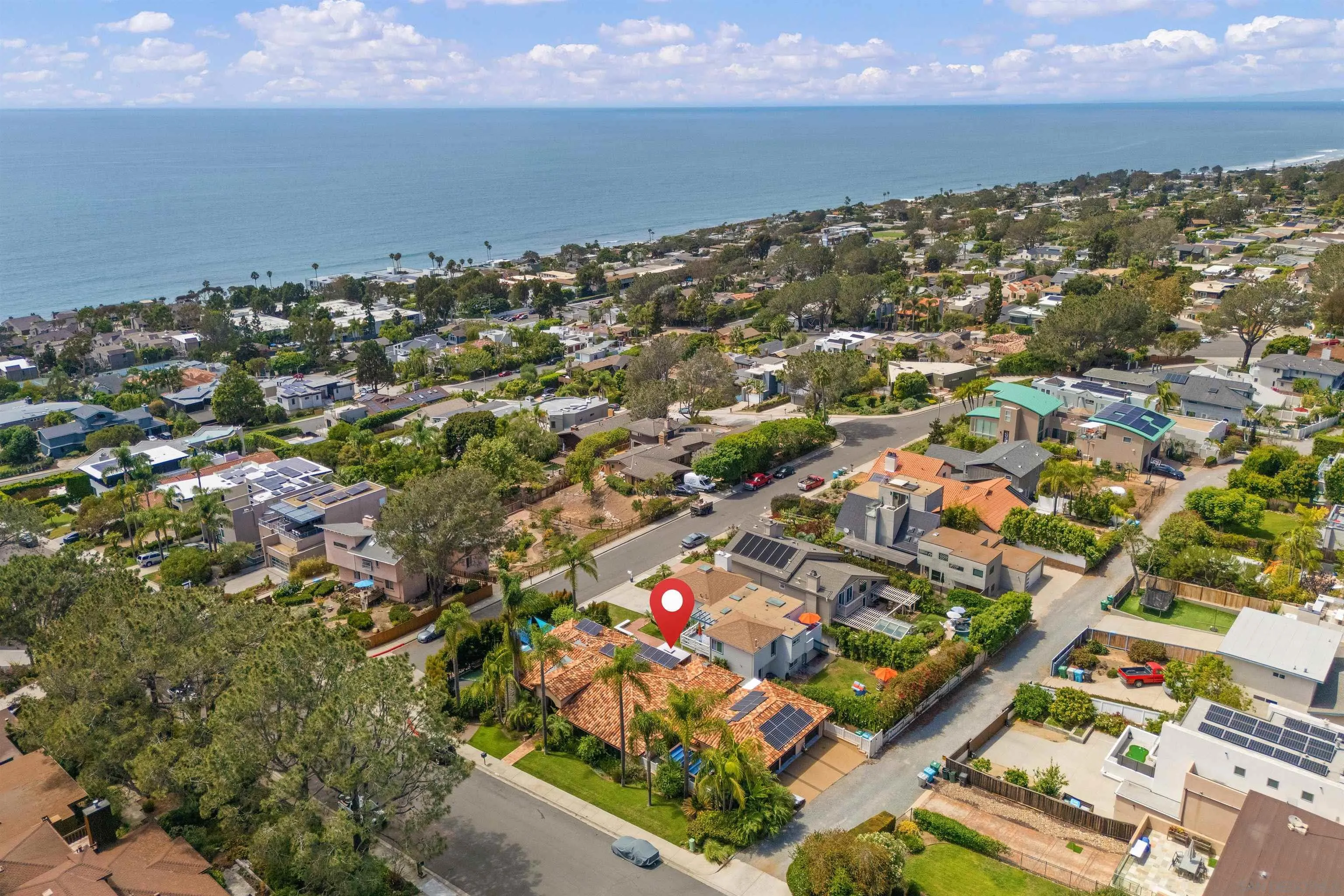 Aerial view of a coastal home among Del Mar houses, with the Pacific Ocean beyond.